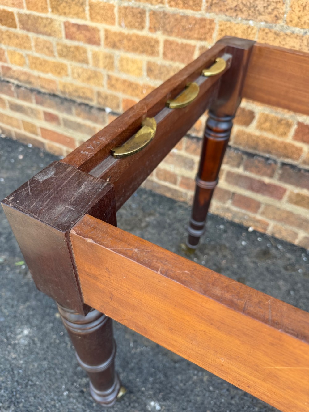 An early nineteenth-century Regency mahogany extending dining table featuring multiple drop-leaf sections and turned legs with brass castors. View XVII