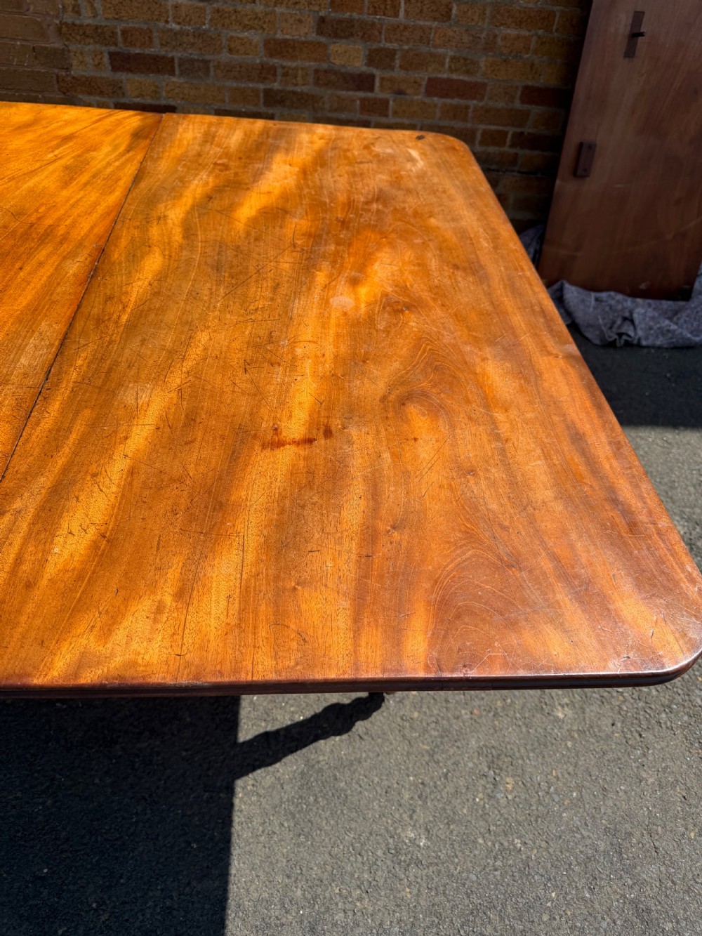 An early nineteenth-century Regency mahogany extending dining table featuring multiple drop-leaf sections and turned legs with brass castors. View XXII