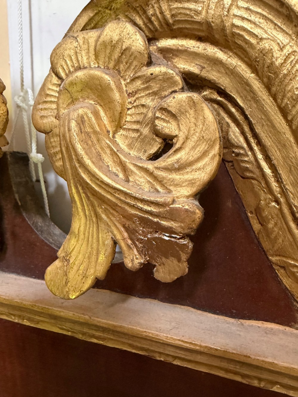 A nineteenth-century George II revival mahogany pier mirror featuring parcel-gilt mouldings, side foliage carvings, a broken pediment, and a carved eagle finial. View VI