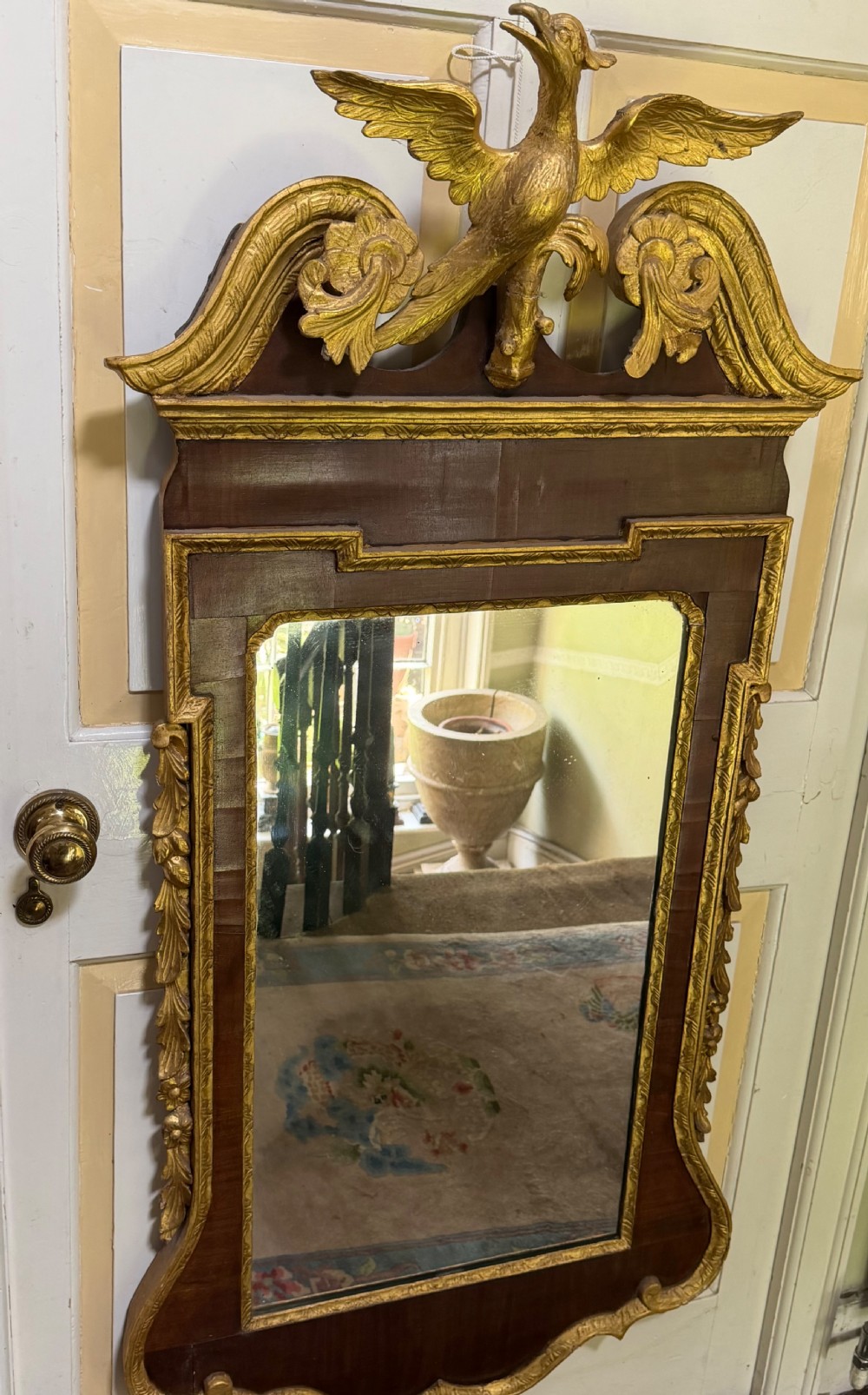 A nineteenth-century George II revival mahogany pier mirror featuring parcel-gilt mouldings, side foliage carvings, a broken pediment, and a carved eagle finial. View VIII