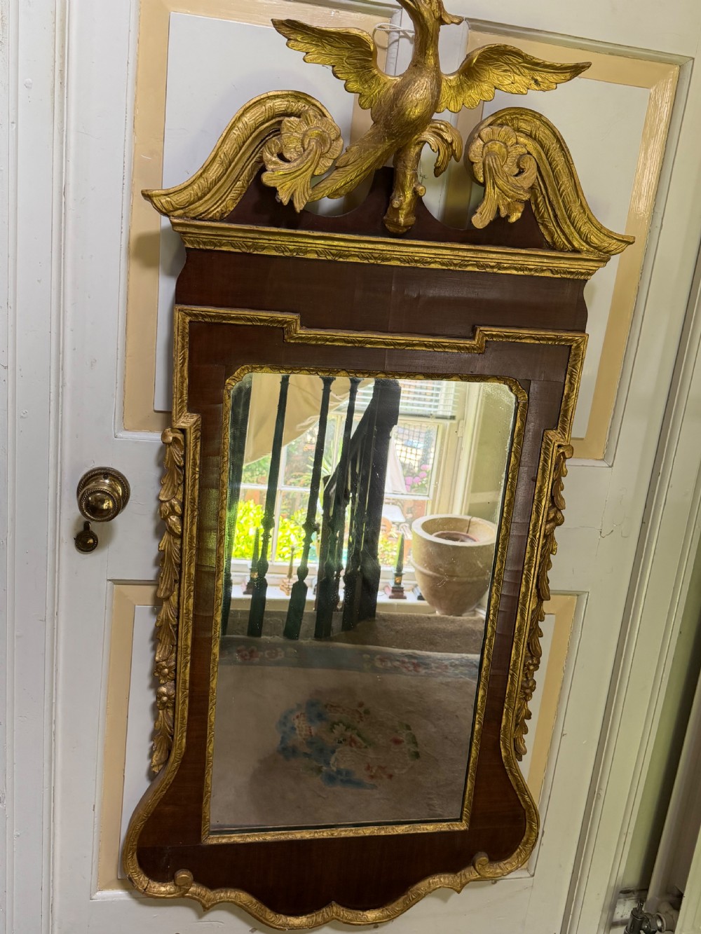 A nineteenth-century George II revival mahogany pier mirror featuring parcel-gilt mouldings, side foliage carvings, a broken pediment, and a carved eagle finial. View IX