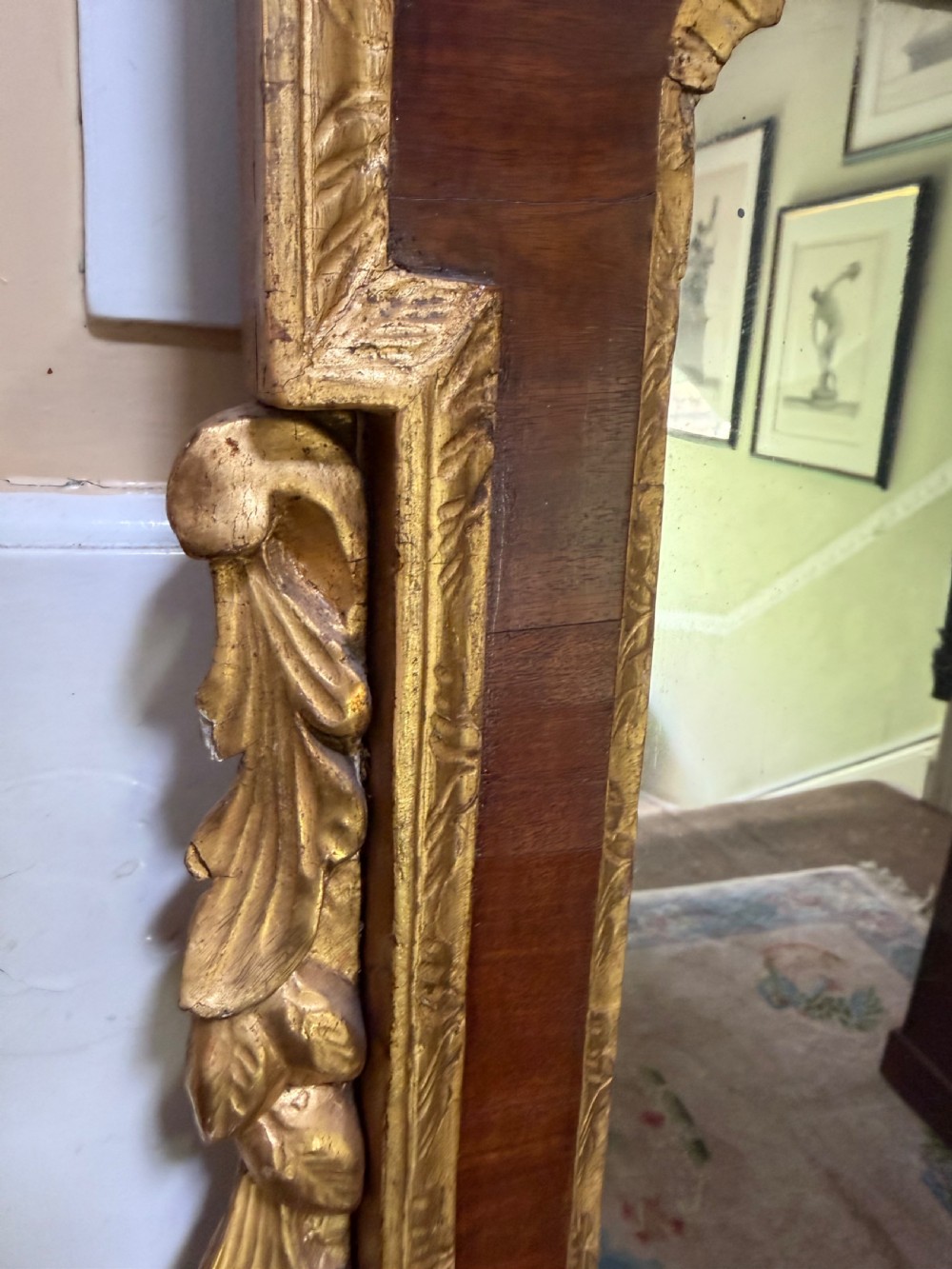 A nineteenth-century George II revival mahogany pier mirror featuring parcel-gilt mouldings, side foliage carvings, a broken pediment, and a carved eagle finial. View X