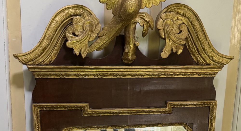 A nineteenth-century George II revival mahogany pier mirror featuring parcel-gilt mouldings, side foliage carvings, a broken pediment, and a carved eagle finial. View XIII