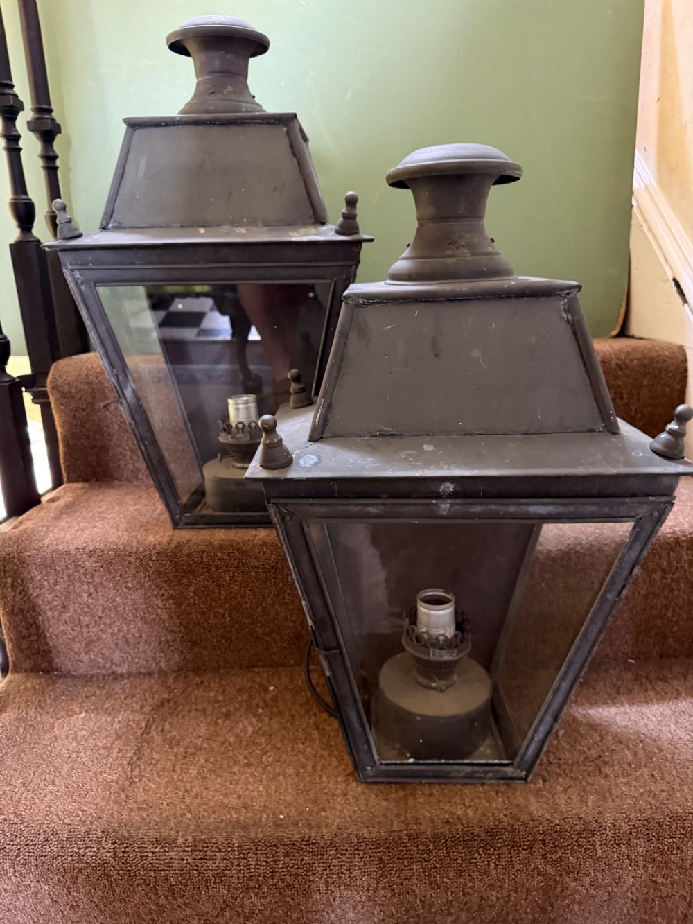 A pair of late nineteenth to early twentieth-century tapered copper wall lanterns with glass panels, top chimneys, and a dark verdigris finish.