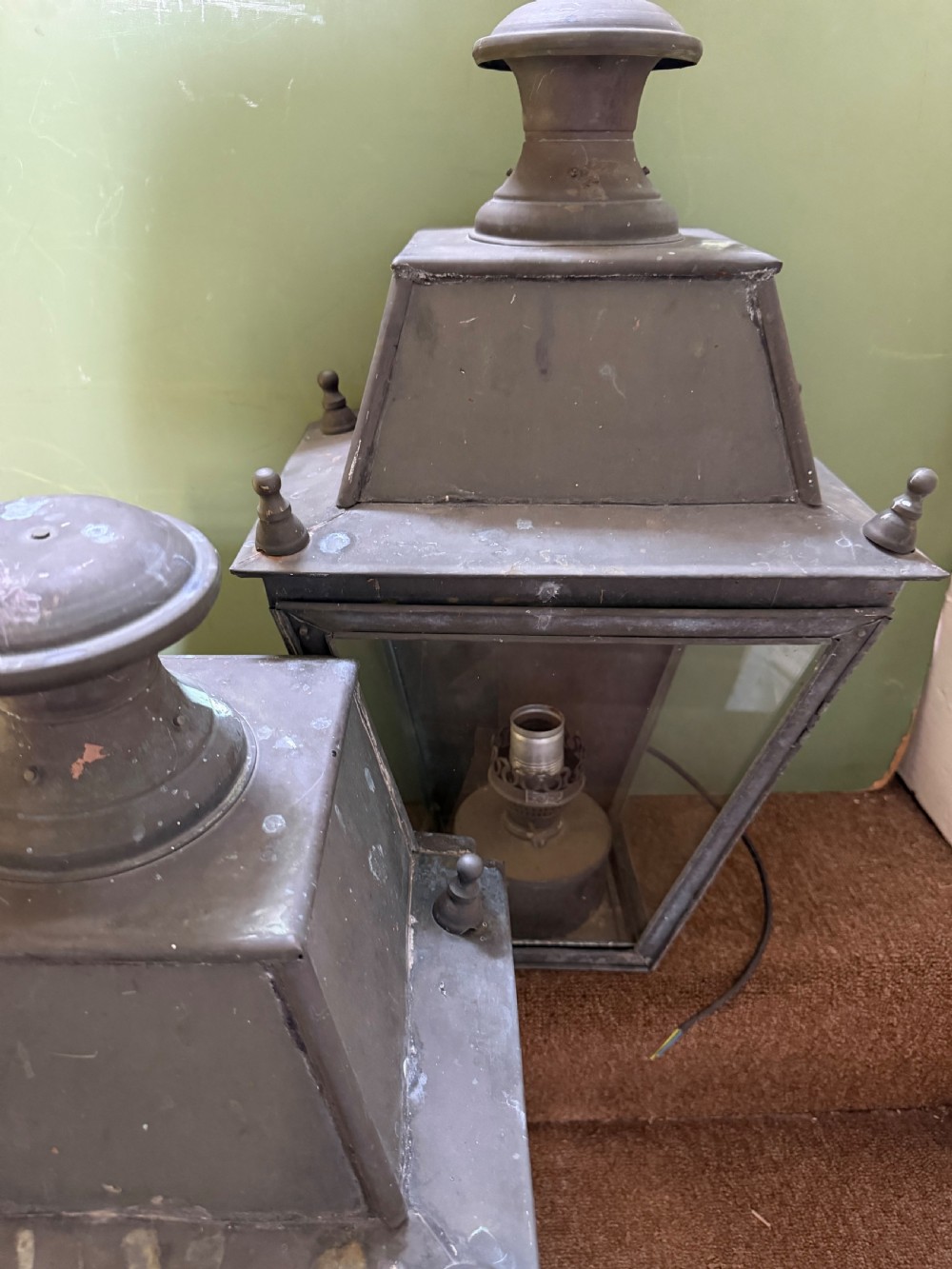 A pair of late nineteenth to early twentieth-century tapered copper wall lanterns with glass panels, top chimneys, and a dark verdigris finish. View XV