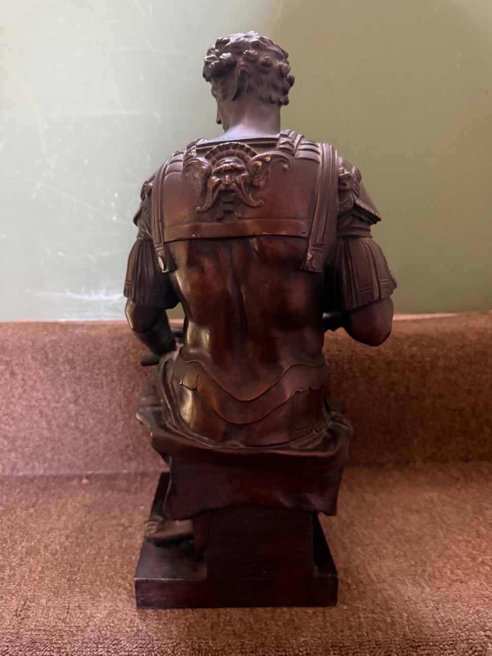 A pair of patinated dark bronze sculptures depicting two seated male figures in classical Roman armour mounted on rectangular bases. View IV