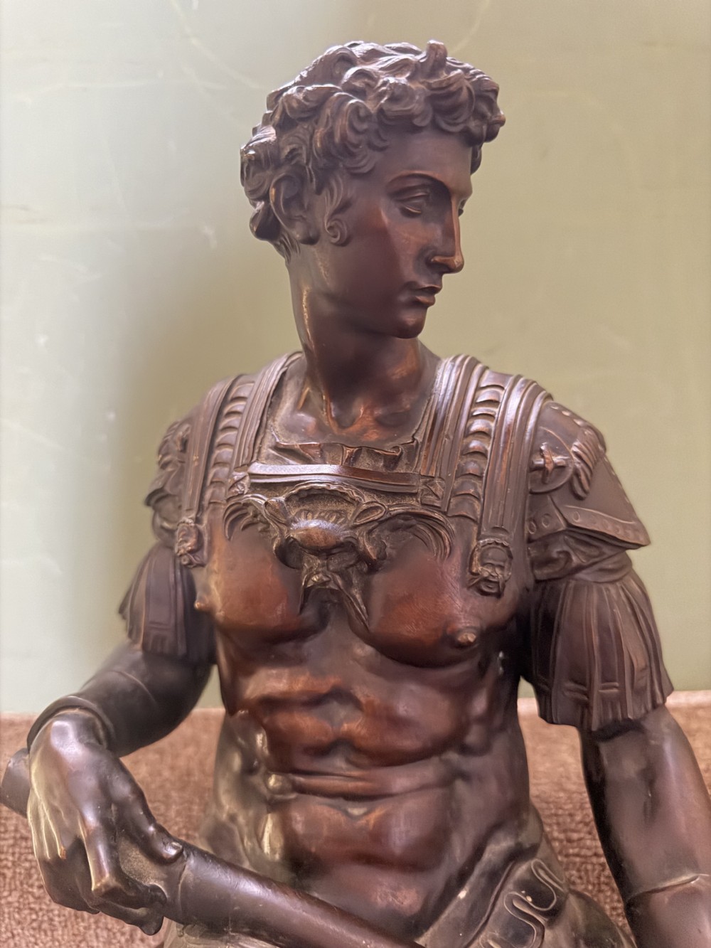 A pair of patinated dark bronze sculptures depicting two seated male figures in classical Roman armour mounted on rectangular bases. View V