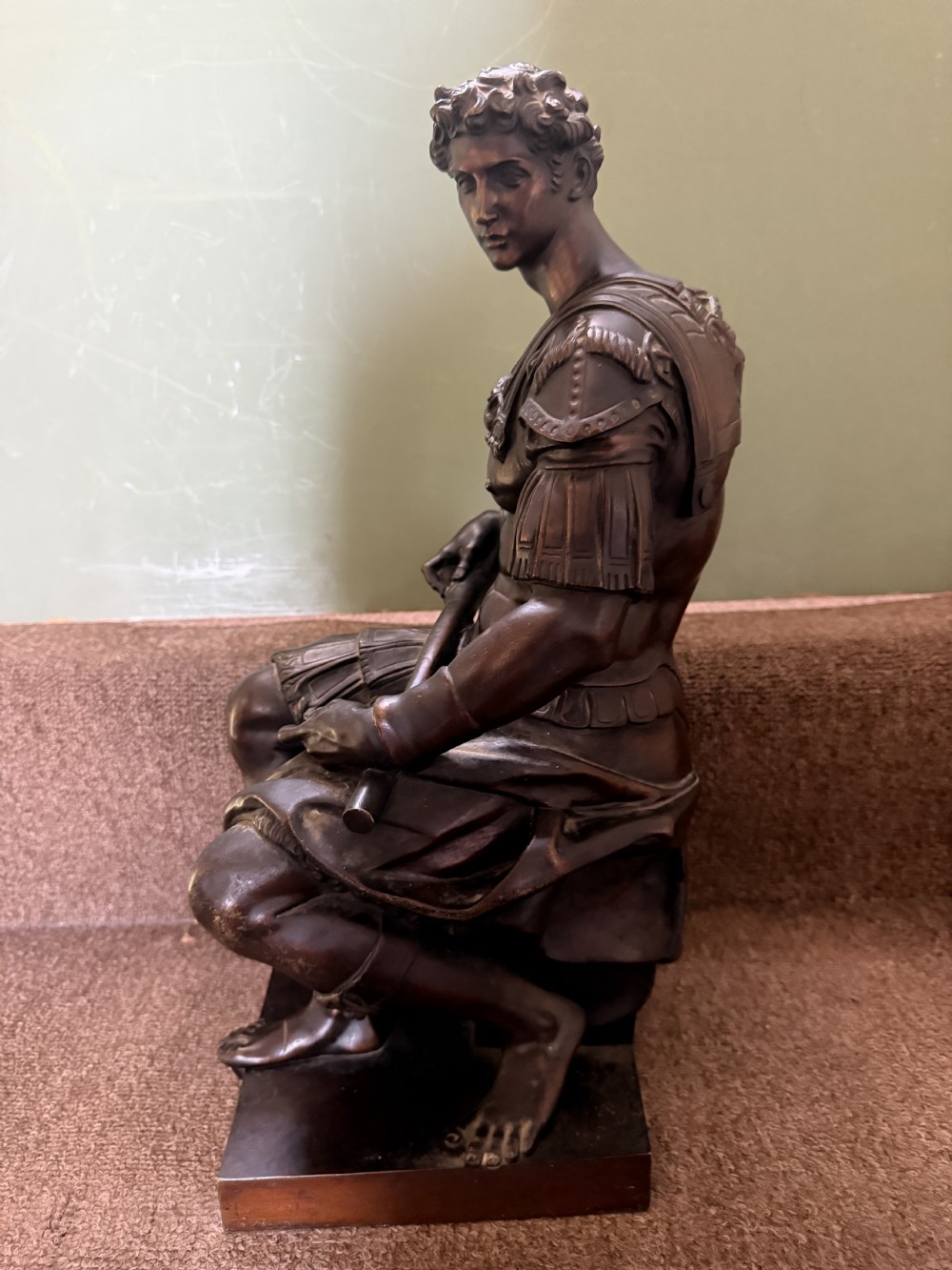 A pair of patinated dark bronze sculptures depicting two seated male figures in classical Roman armour mounted on rectangular bases. View VII