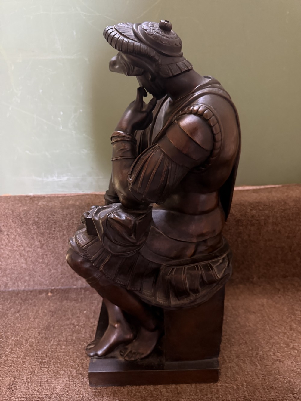 A pair of patinated dark bronze sculptures depicting two seated male figures in classical Roman armour mounted on rectangular bases. View IX