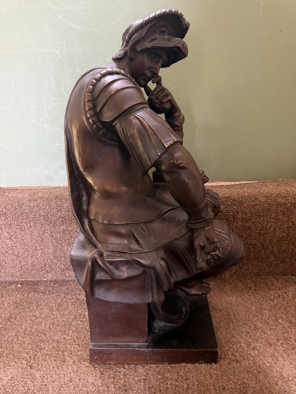 A pair of patinated dark bronze sculptures depicting two seated male figures in classical Roman armour mounted on rectangular bases. View XI