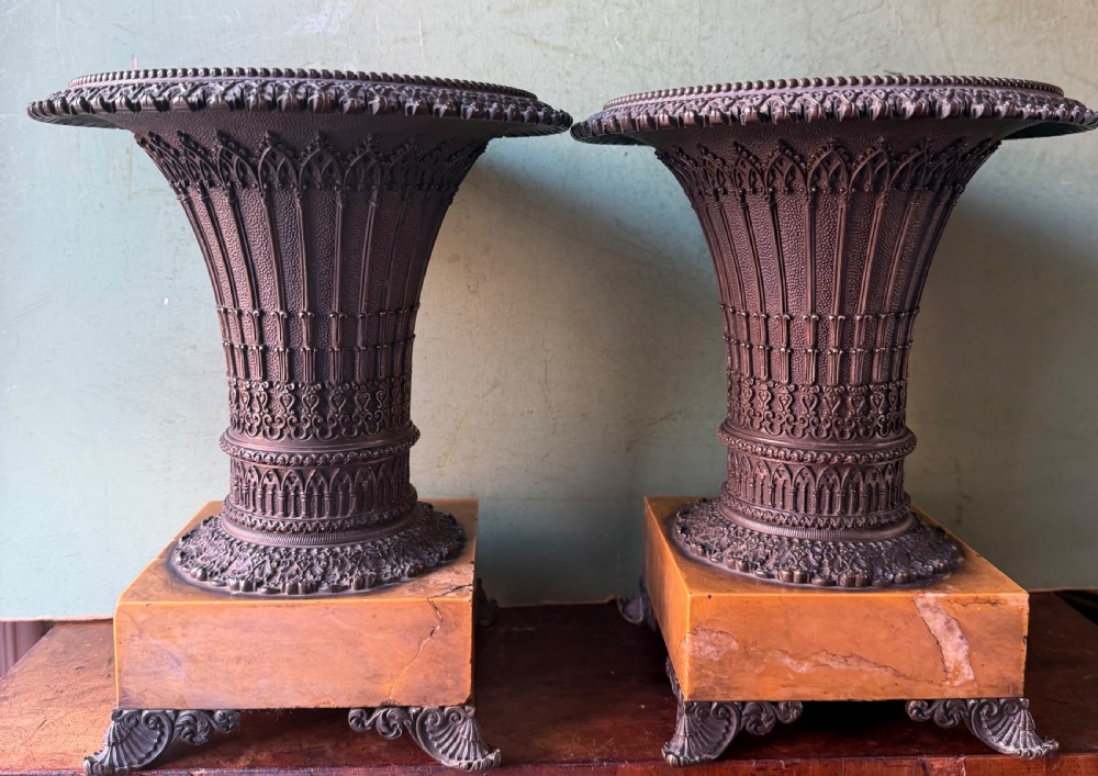 A pair of early nineteenth-century French bronze flared urns with Gothic tracery detailing, set upon square yellow Siena marble plinth bases with bronze bracket feet. View III