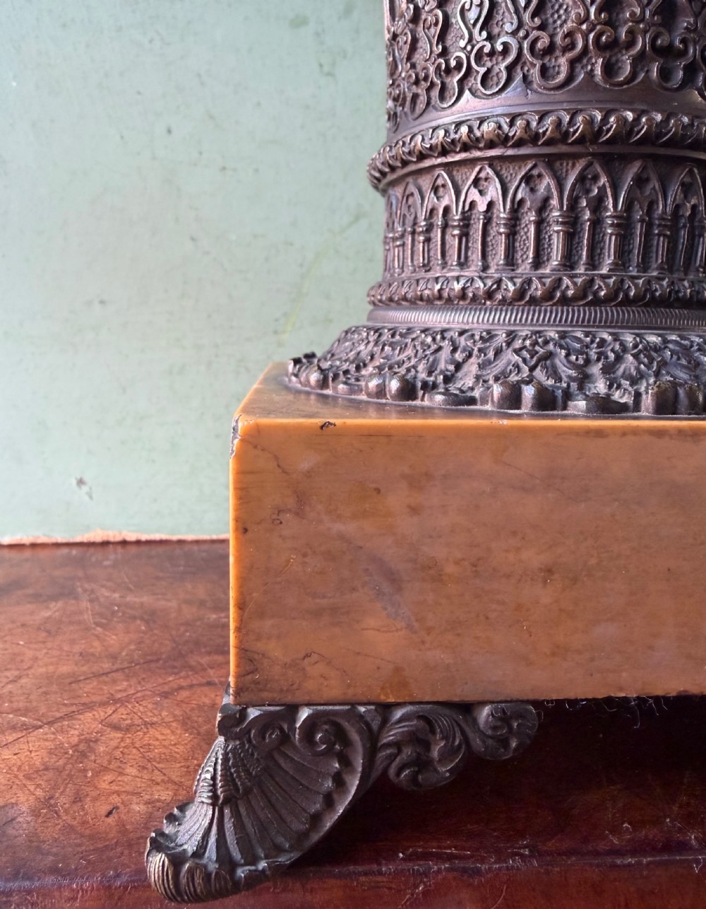 A pair of early nineteenth-century French bronze flared urns with Gothic tracery detailing, set upon square yellow Siena marble plinth bases with bronze bracket feet. View IV