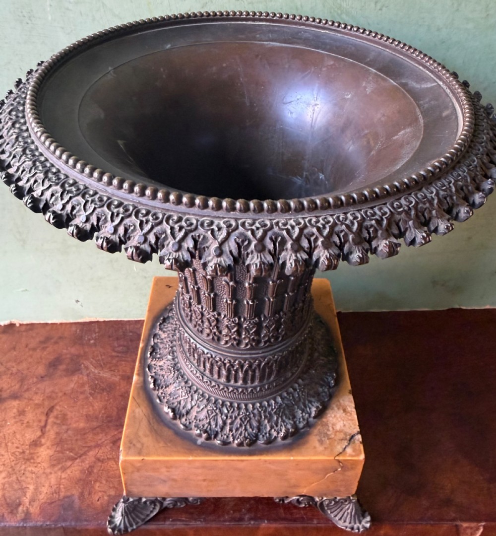 A pair of early nineteenth-century French bronze flared urns with Gothic tracery detailing, set upon square yellow Siena marble plinth bases with bronze bracket feet. View VI