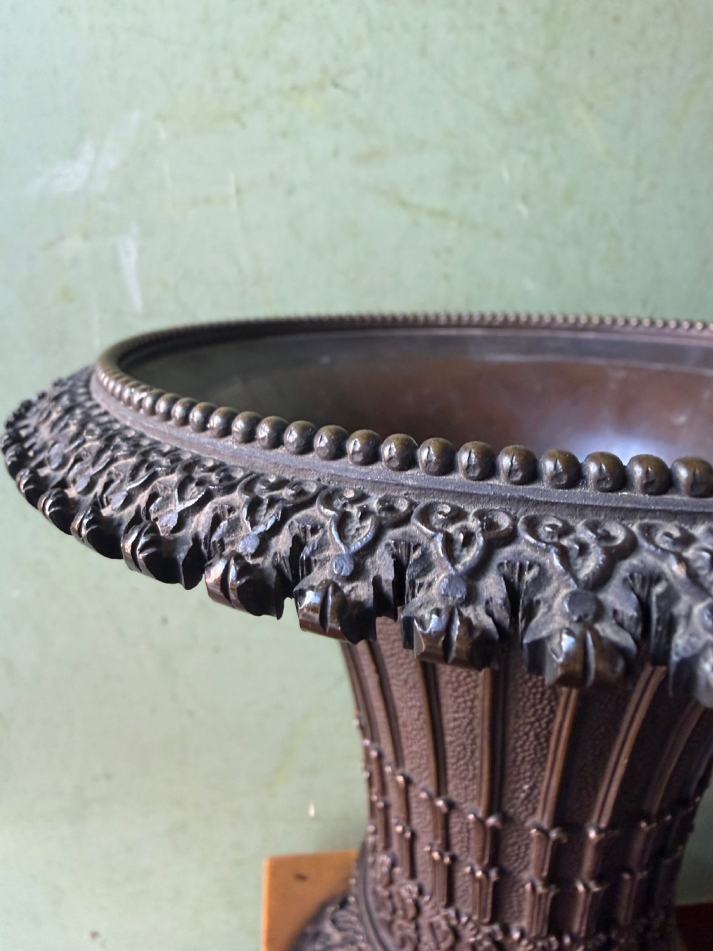 A pair of early nineteenth-century French bronze flared urns with Gothic tracery detailing, set upon square yellow Siena marble plinth bases with bronze bracket feet. View VII