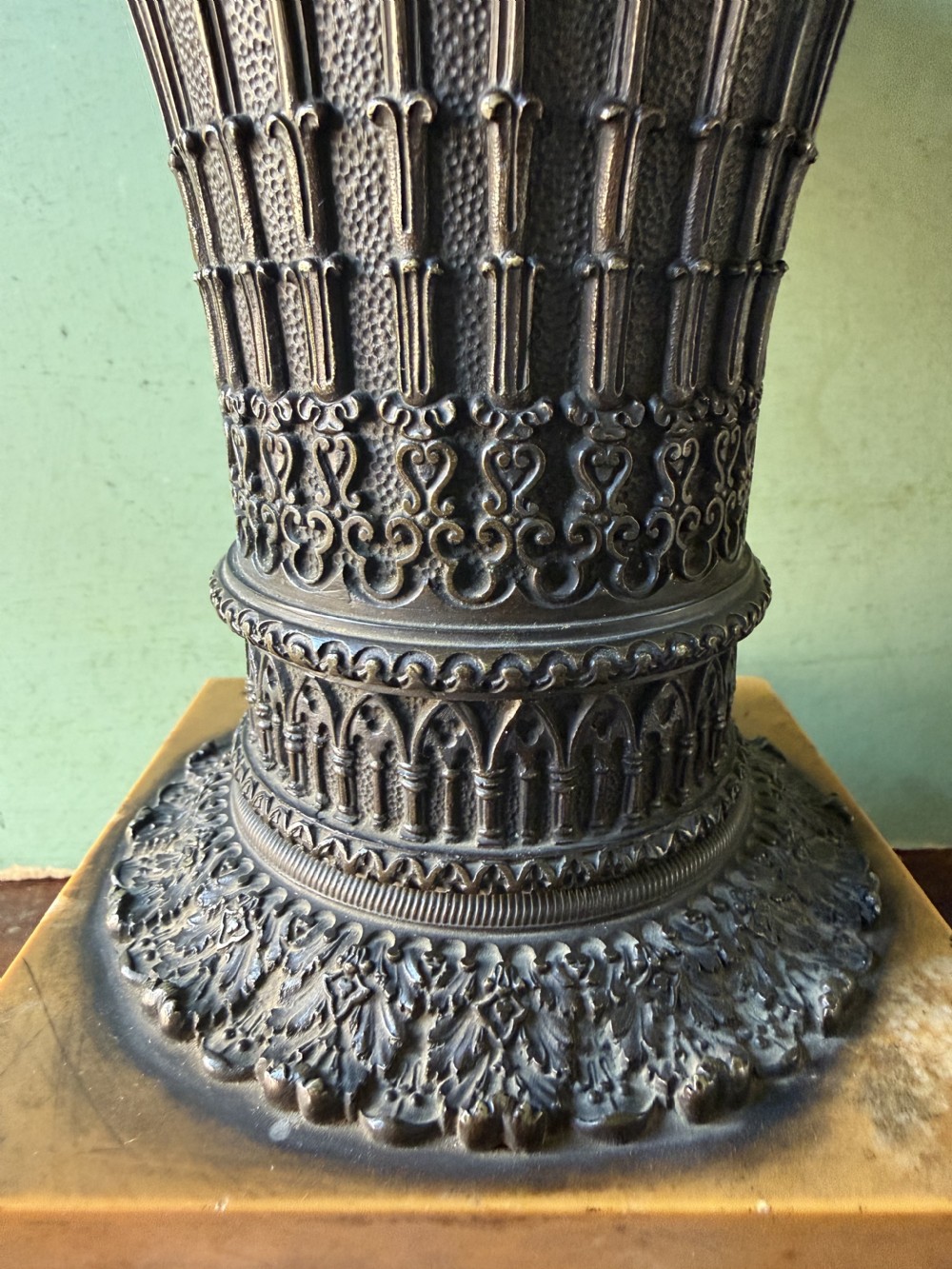 A pair of early nineteenth-century French bronze flared urns with Gothic tracery detailing, set upon square yellow Siena marble plinth bases with bronze bracket feet. View VIII