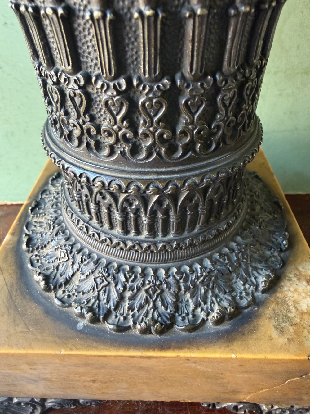 A pair of early nineteenth-century French bronze flared urns with Gothic tracery detailing, set upon square yellow Siena marble plinth bases with bronze bracket feet. View XII