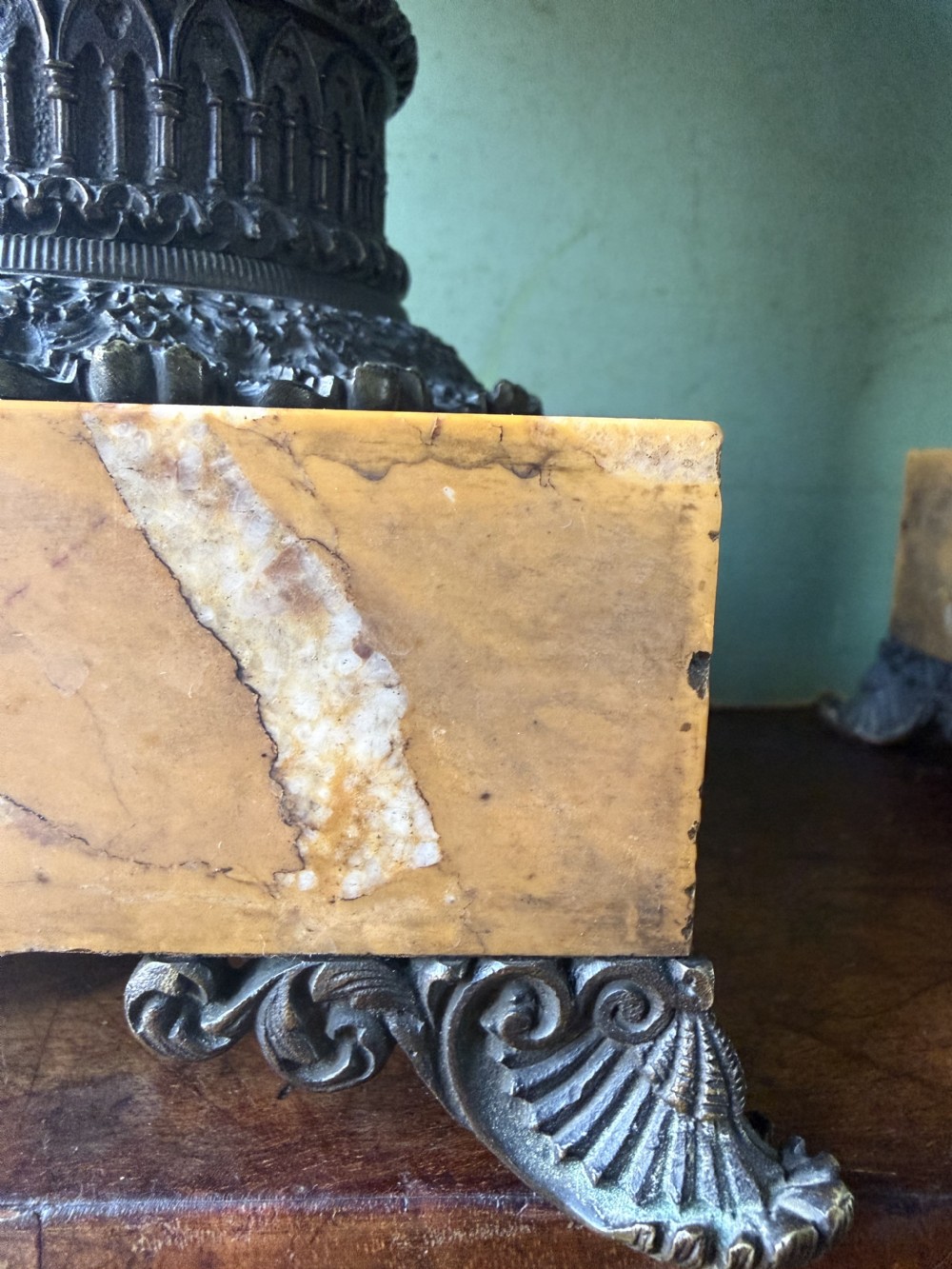 A pair of early nineteenth-century French bronze flared urns with Gothic tracery detailing, set upon square yellow Siena marble plinth bases with bronze bracket feet. View XVI