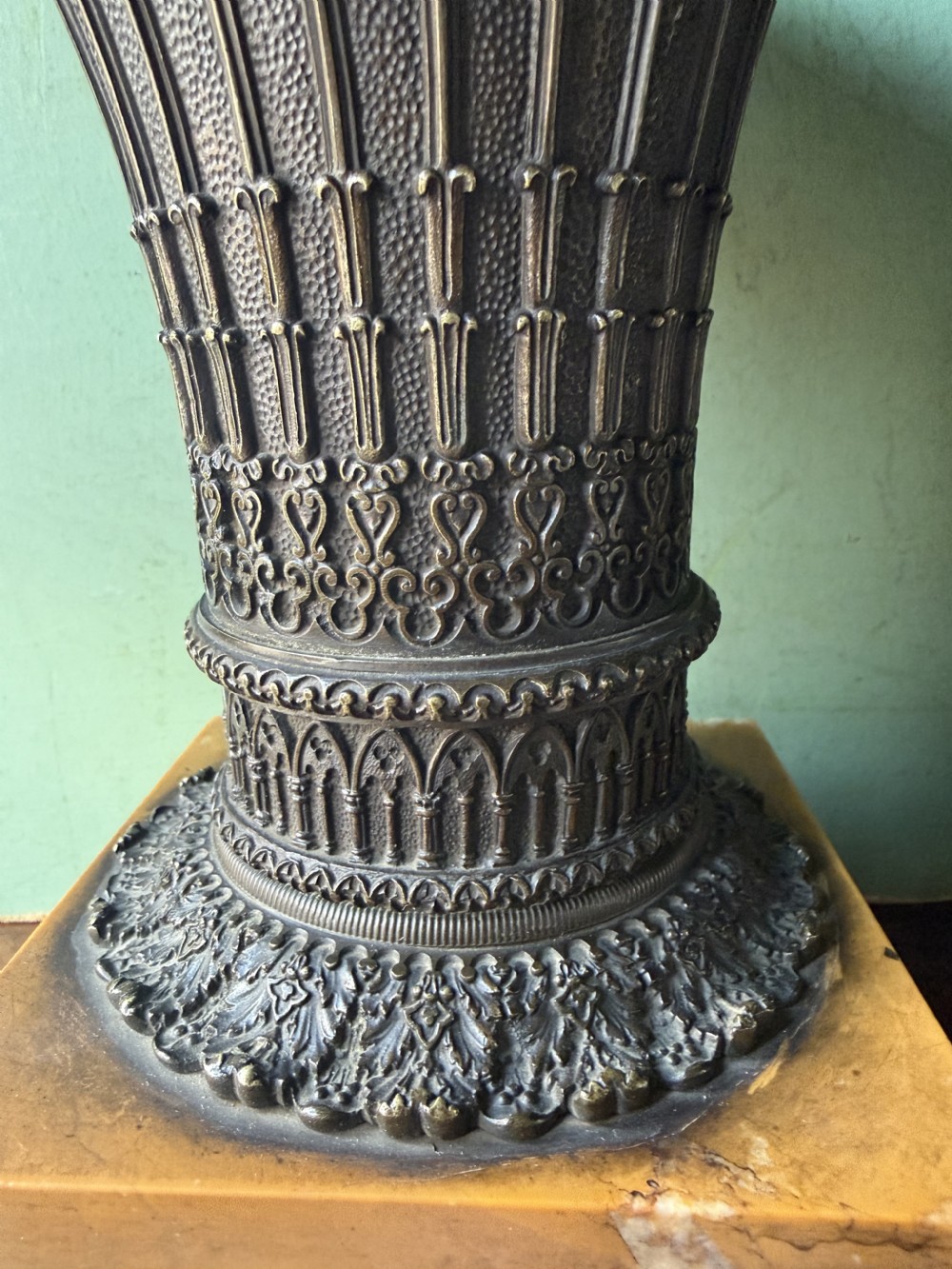 A pair of early nineteenth-century French bronze flared urns with Gothic tracery detailing, set upon square yellow Siena marble plinth bases with bronze bracket feet. View XVII