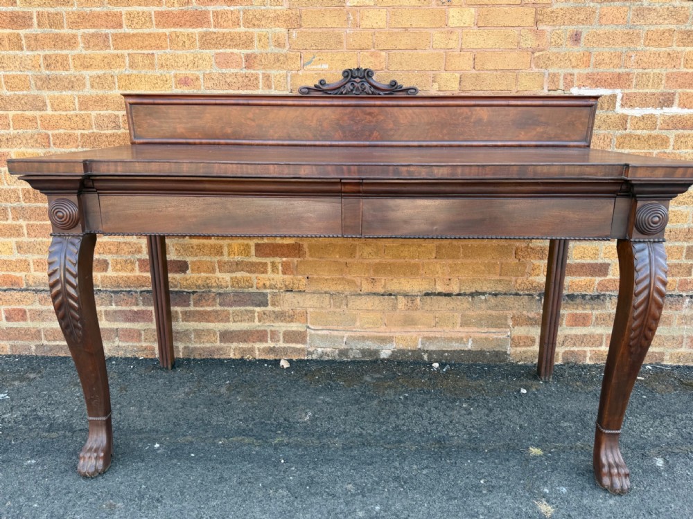 A large early 19th-century George IV mahogany serving table featuring a raised gallery back with carved cresting, carved cabriole front legs, and lion paw feet. View II