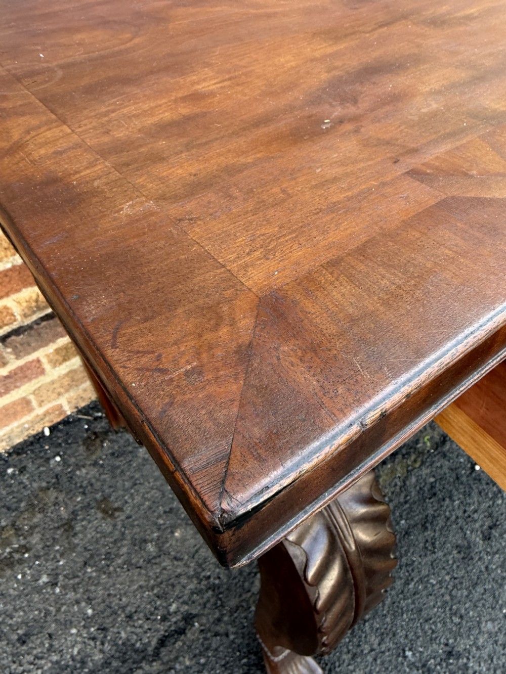 A large early 19th-century George IV mahogany serving table featuring a raised gallery back with carved cresting, carved cabriole front legs, and lion paw feet. View X