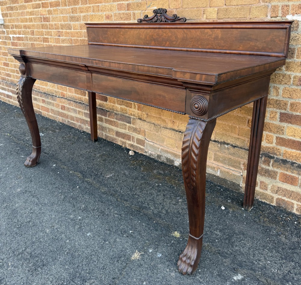 A large early 19th-century George IV mahogany serving table featuring a raised gallery back with carved cresting, carved cabriole front legs, and lion paw feet. View XII