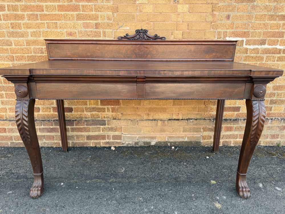 A large early 19th-century George IV mahogany serving table featuring a raised gallery back with carved cresting, carved cabriole front legs, and lion paw feet. View XV