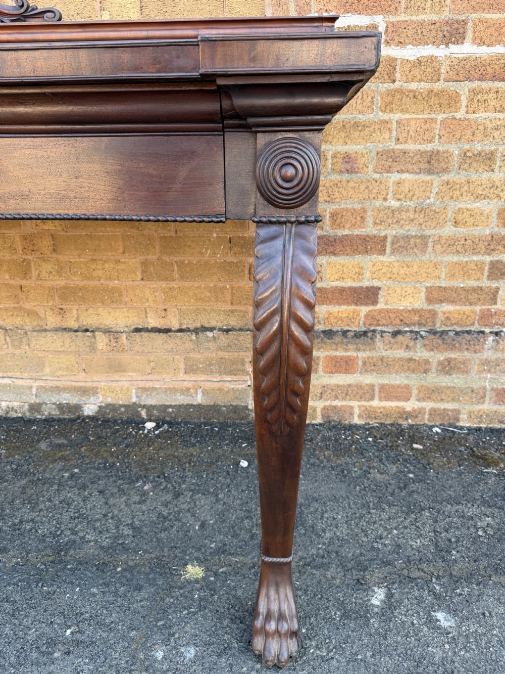 A large early 19th-century George IV mahogany serving table featuring a raised gallery back with carved cresting, carved cabriole front legs, and lion paw feet. View XVII