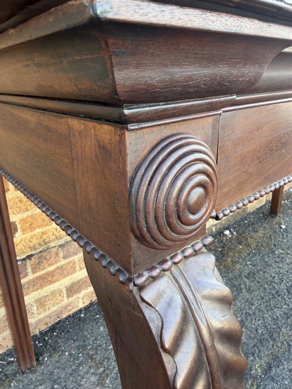 A large early 19th-century George IV mahogany serving table featuring a raised gallery back with carved cresting, carved cabriole front legs, and lion paw feet. View XVIII