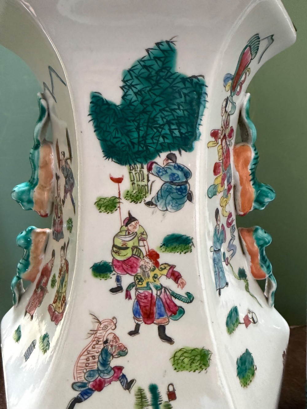 A pair of hexagonal Chinese famille-verte porcelain lamps decorated with figures in traditional scenes and set on gilded bases. View XII