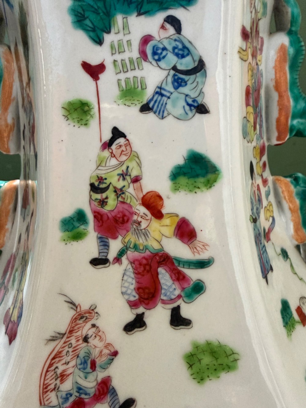 A pair of hexagonal Chinese famille-verte porcelain lamps decorated with figures in traditional scenes and set on gilded bases. View XVII