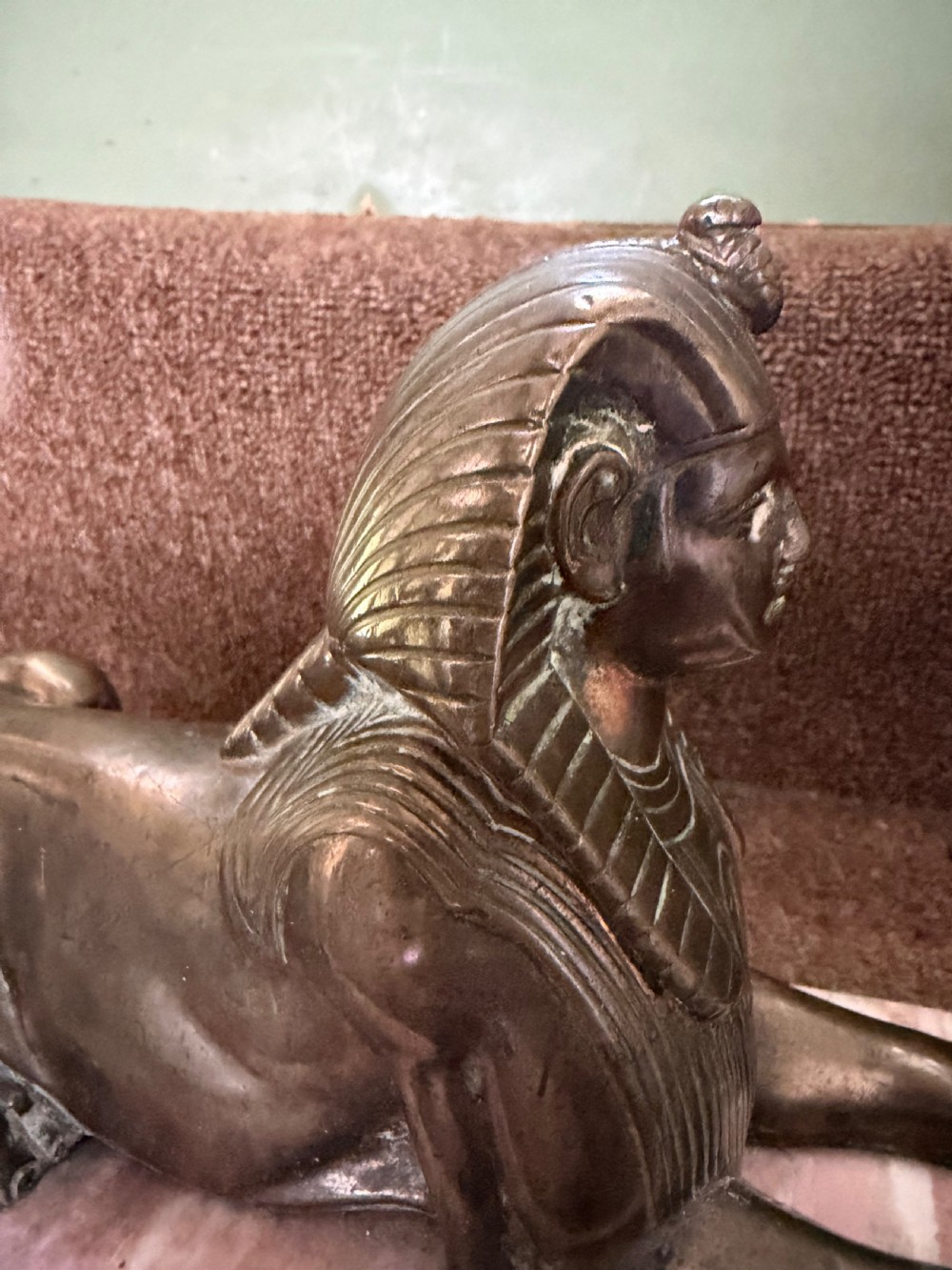 A pair of bronze recumbent sphinx sculptures featuring detailed Nemes headdresses mounted on rectangular pink marble bases. View IV
