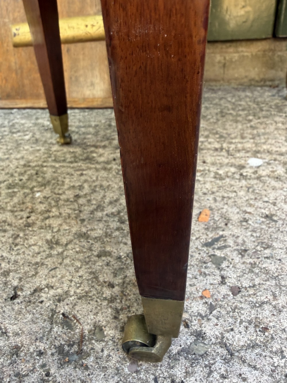 An 18th-century George III mahogany oval wine cooler with thick brass bands and brass handles, resting on a four-legged tapered stand with castors. View V