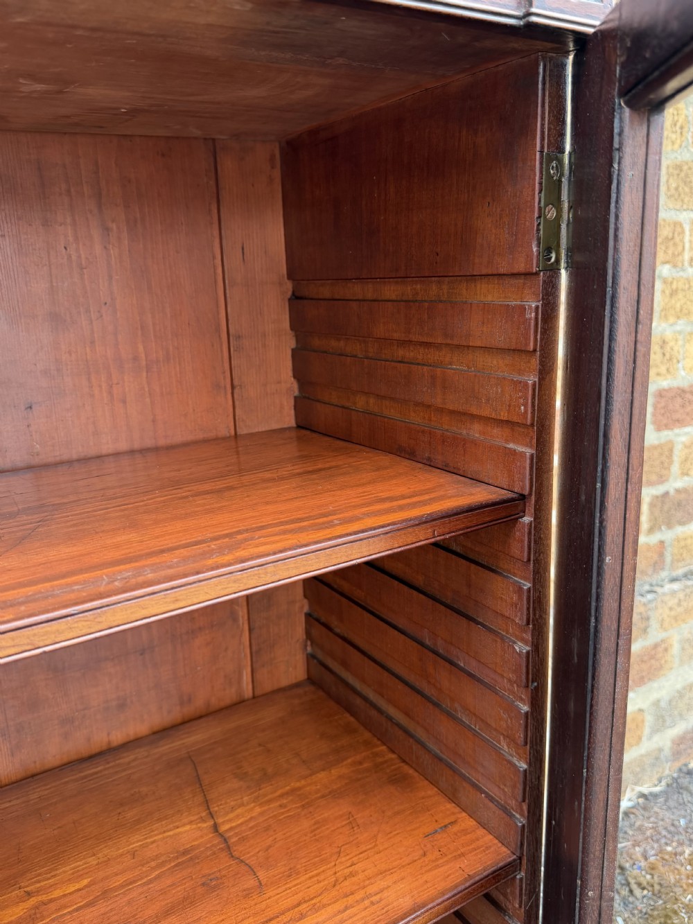 An early nineteenth-century George III mahogany low bookcase featuring two top frieze drawers over glazed twin doors and turned feet. View IX
