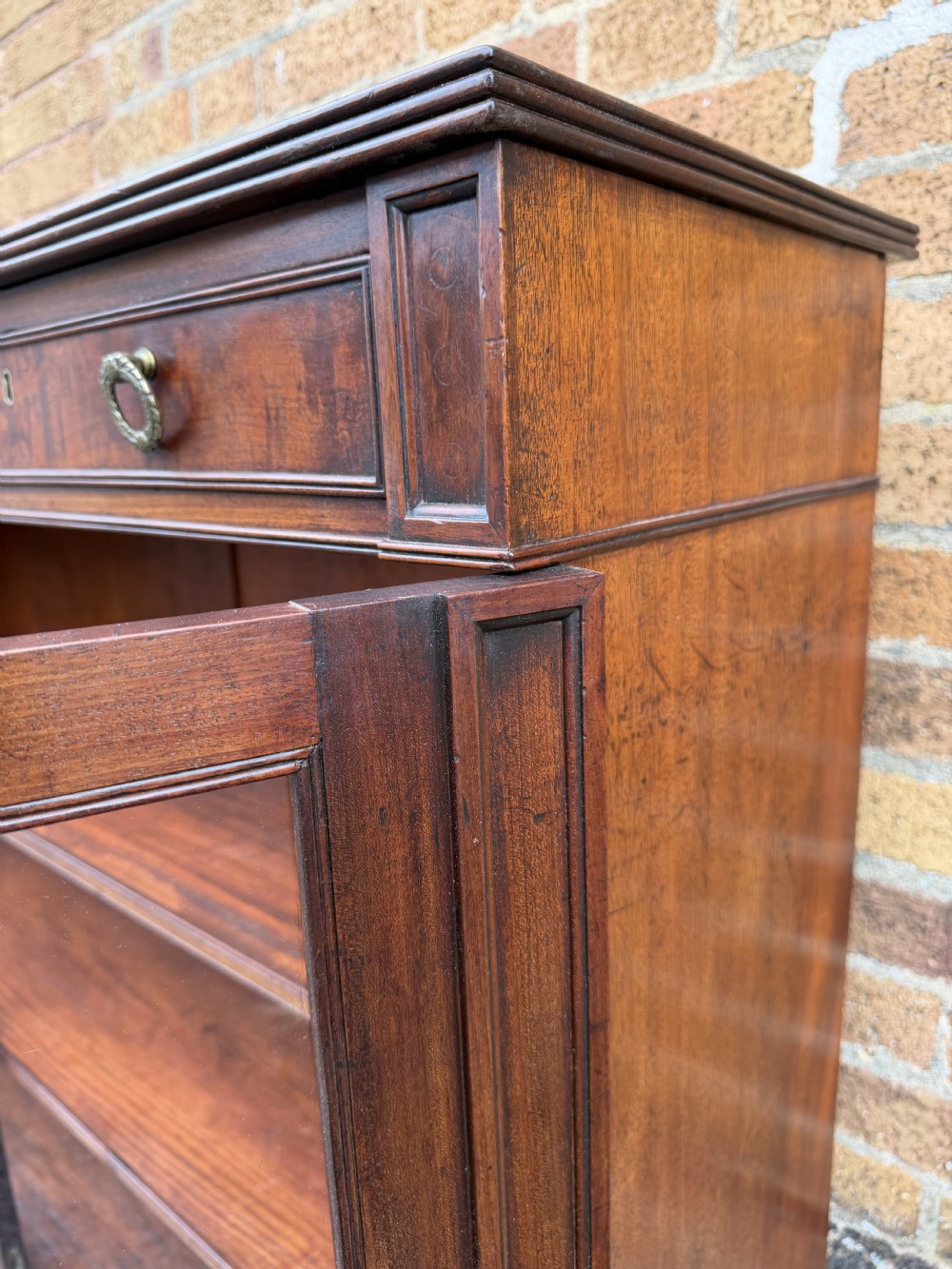 An early nineteenth-century George III mahogany low bookcase featuring two top frieze drawers over glazed twin doors and turned feet. View X