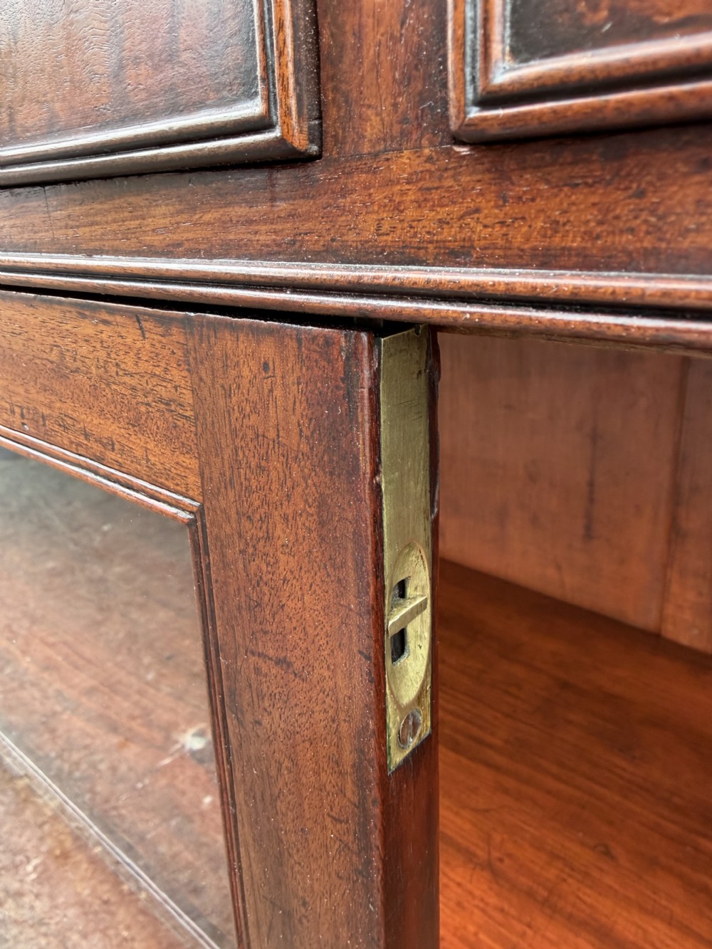 An early nineteenth-century George III mahogany low bookcase featuring two top frieze drawers over glazed twin doors and turned feet. View XI