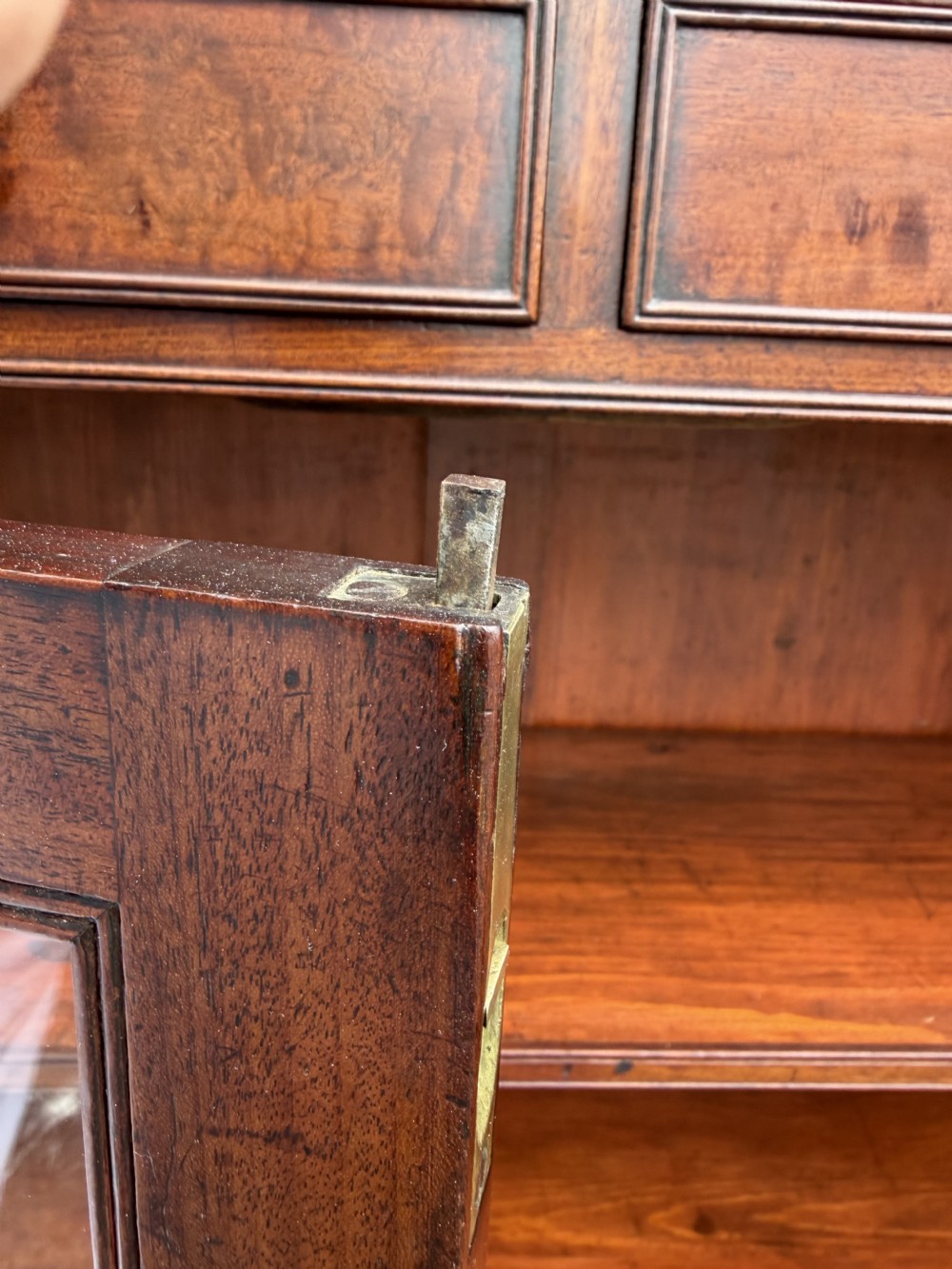 An early nineteenth-century George III mahogany low bookcase featuring two top frieze drawers over glazed twin doors and turned feet. View XII