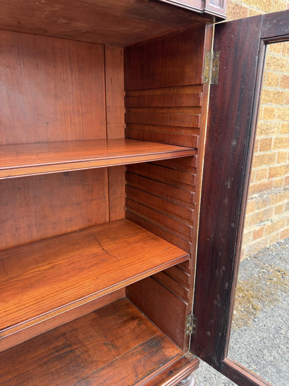 An early nineteenth-century George III mahogany low bookcase featuring two top frieze drawers over glazed twin doors and turned feet. View XIII
