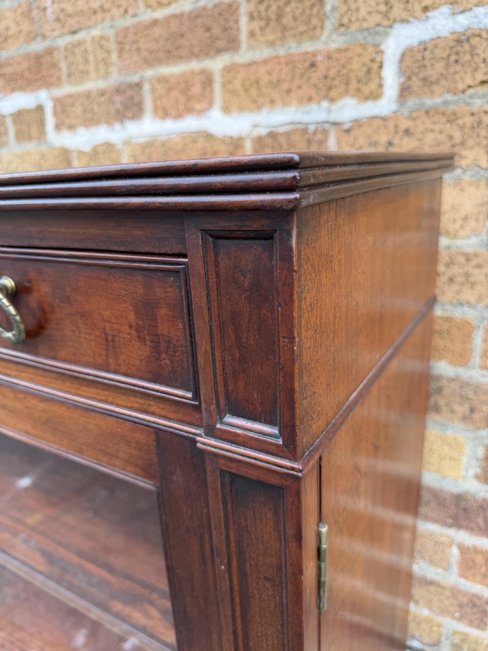 An early nineteenth-century George III mahogany low bookcase featuring two top frieze drawers over glazed twin doors and turned feet. View XV