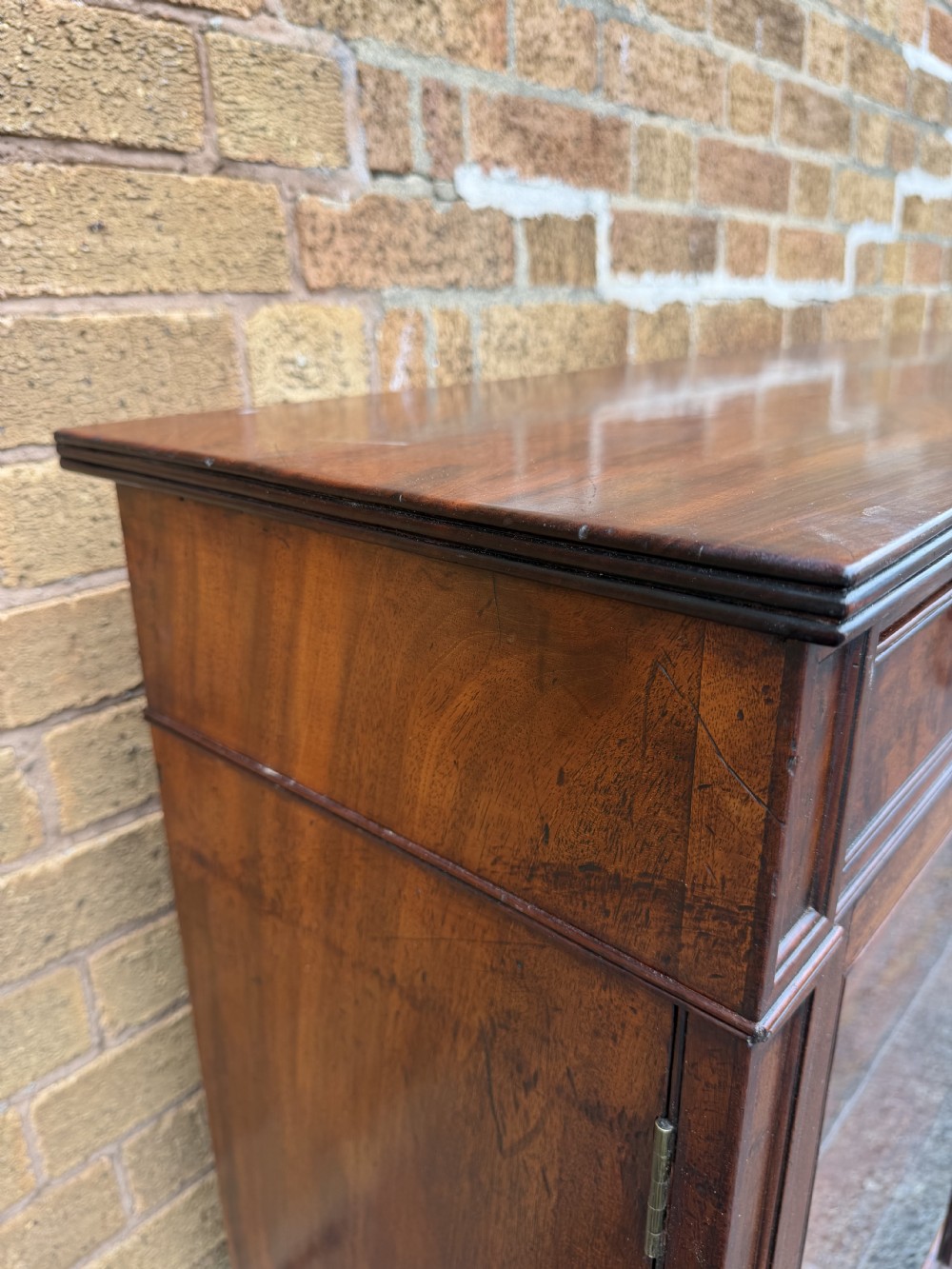 An early nineteenth-century George III mahogany low bookcase featuring two top frieze drawers over glazed twin doors and turned feet. View XVII