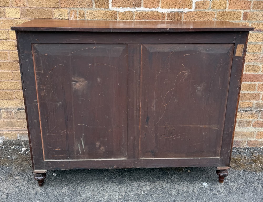 An early nineteenth-century George III mahogany low bookcase featuring two top frieze drawers over glazed twin doors and turned feet. View XXIV