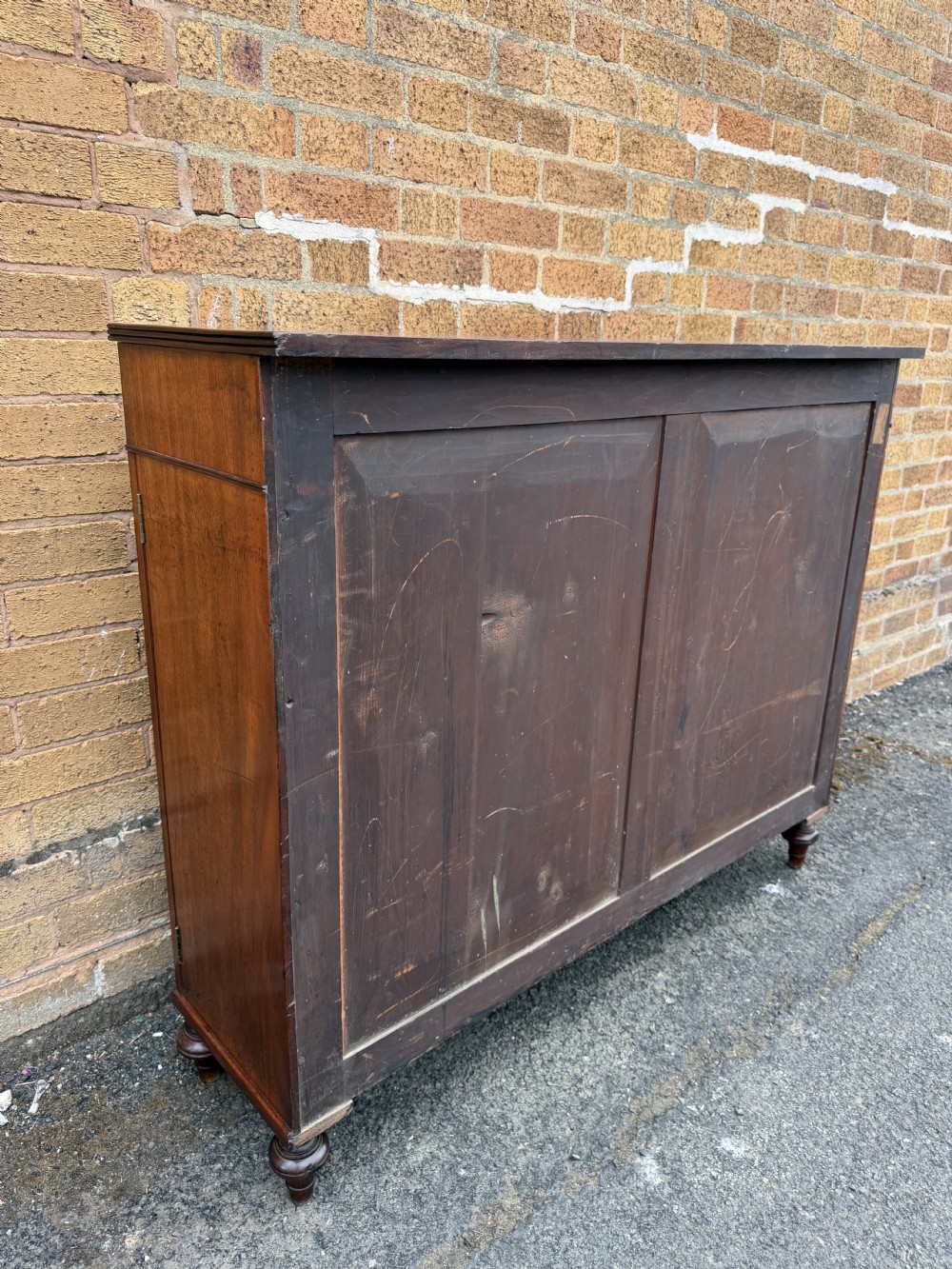 An early nineteenth-century George III mahogany low bookcase featuring two top frieze drawers over glazed twin doors and turned feet. View XXV