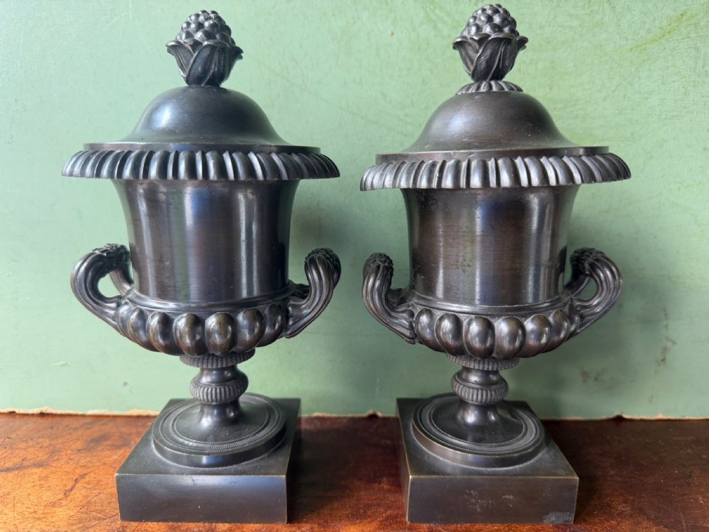 A pair of Regency patinated bronze campana-shaped cassolettes with gadrooned bodies, twin handles, pinecone finials, and square bases. View II