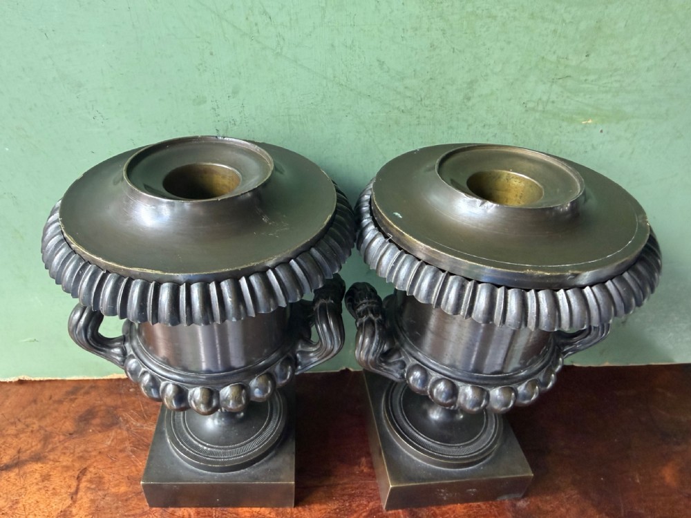 A pair of Regency patinated bronze campana-shaped cassolettes with gadrooned bodies, twin handles, pinecone finials, and square bases. View VII