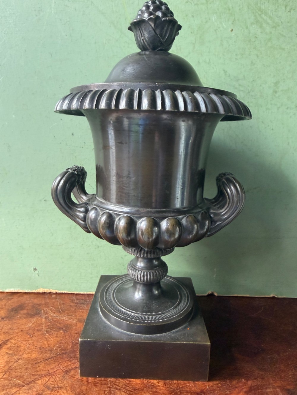 A pair of Regency patinated bronze campana-shaped cassolettes with gadrooned bodies, twin handles, pinecone finials, and square bases. View XIII