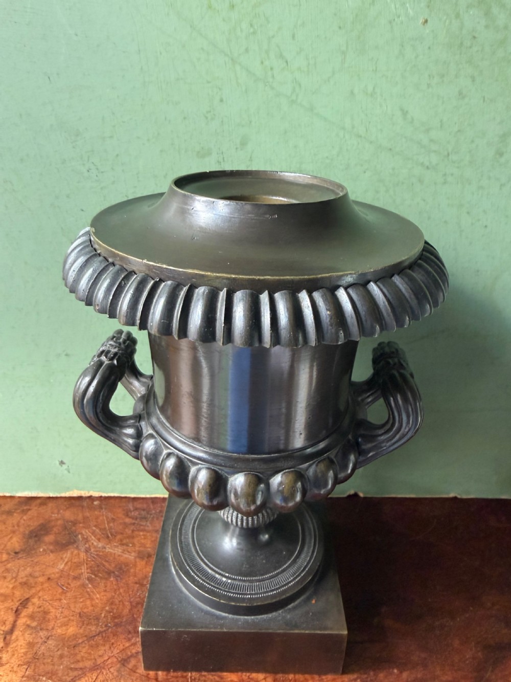 A pair of Regency patinated bronze campana-shaped cassolettes with gadrooned bodies, twin handles, pinecone finials, and square bases. View XIV