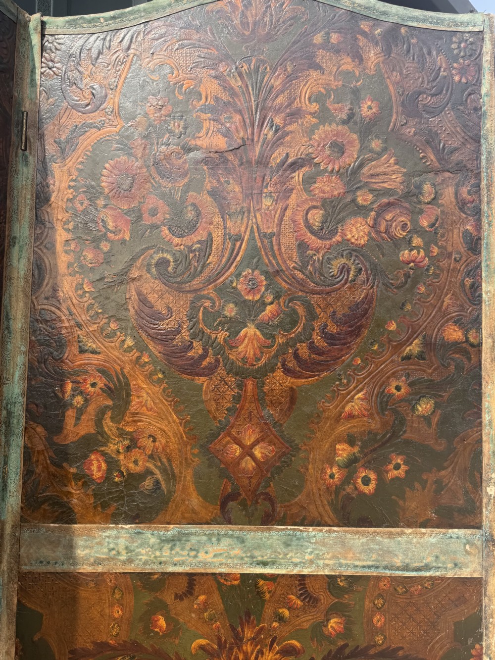 A late nineteenth-century four-fold canvas room screen featuring polychrome floral and scroll decoration in warm brown and green tones with serpentine cresting. View III