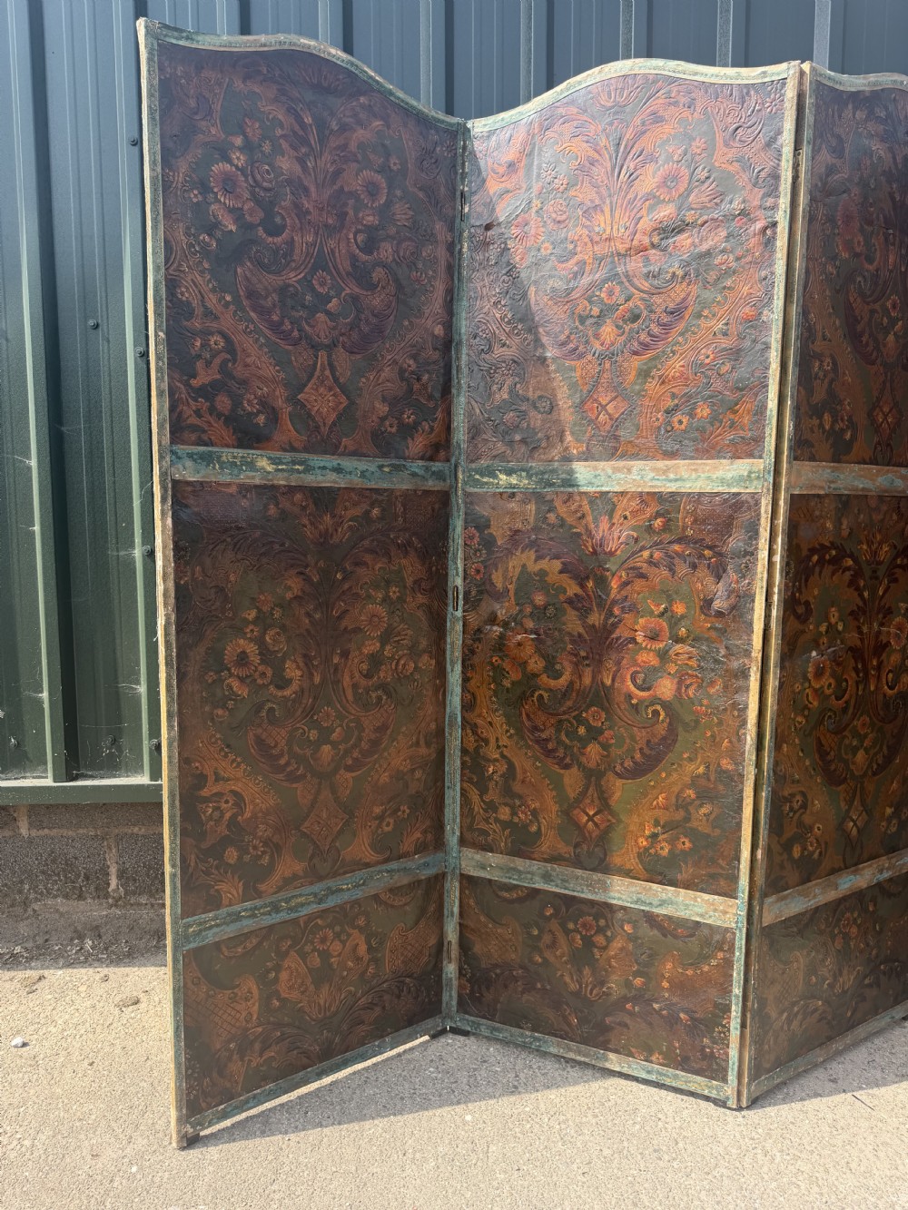 A late nineteenth-century four-fold canvas room screen featuring polychrome floral and scroll decoration in warm brown and green tones with serpentine cresting. View XIII
