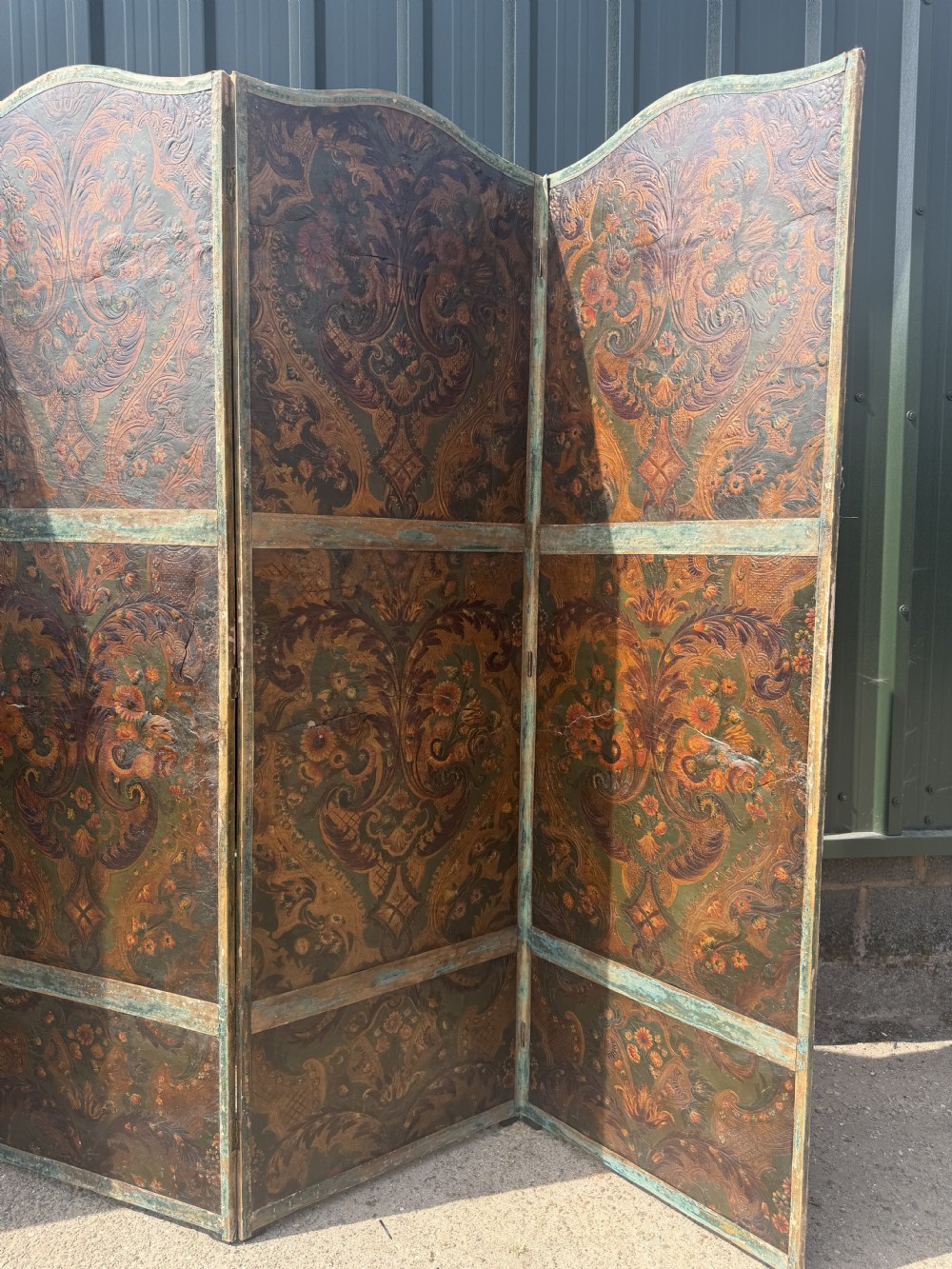 A late nineteenth-century four-fold canvas room screen featuring polychrome floral and scroll decoration in warm brown and green tones with serpentine cresting. View XVI