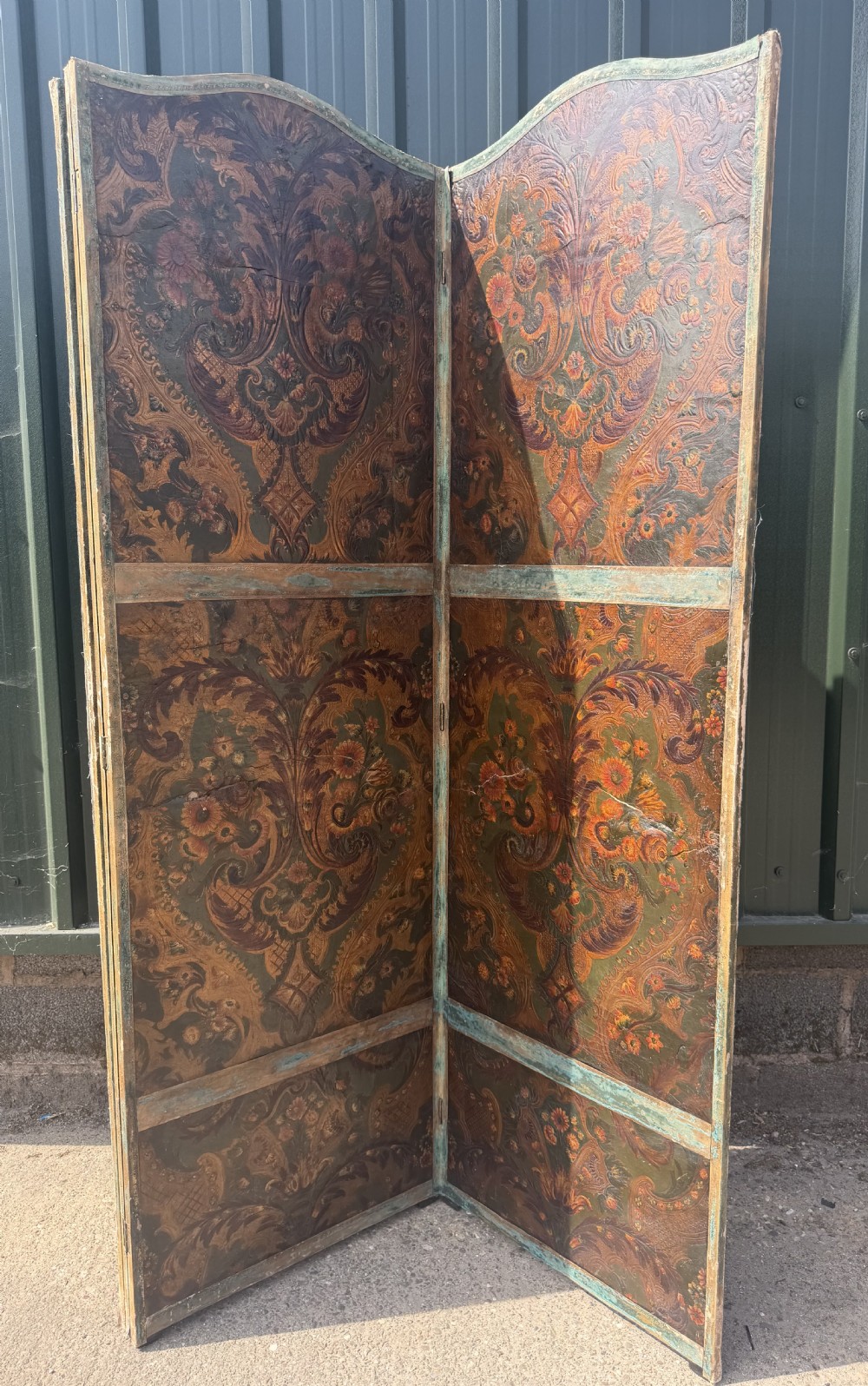 A late nineteenth-century four-fold canvas room screen featuring polychrome floral and scroll decoration in warm brown and green tones with serpentine cresting. View XVIII