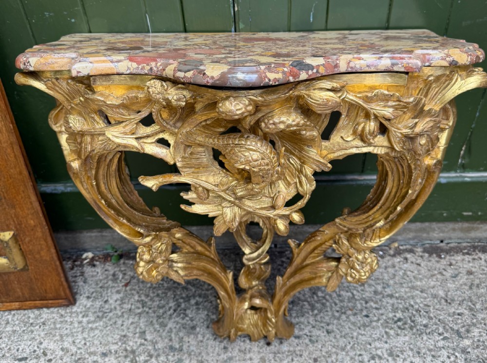 Late C18th/early C19th French carved gilt-wood console with a ‘breche d’alep’ figured marble top.